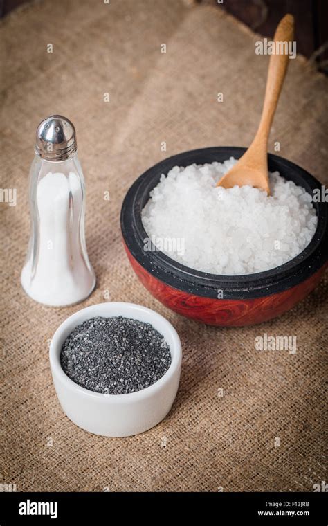 Salt Cellar Black And Sea Salt In Bowl On Burlap Background Stock