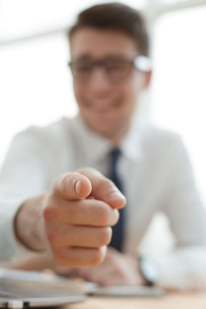 Bonito empresário sorridente apontando o dedo para você Foto Premium