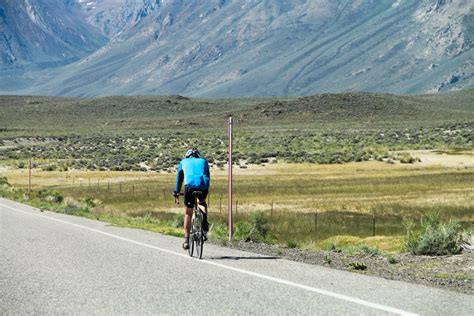 Free Stock Photo Of Bicyclist On Road By Fields And Mountain