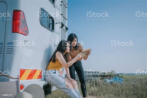 Asian Chinese Lesbian Couple Reading Digital Tablet At The Back Of