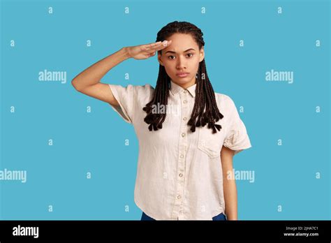 Yes sir. Portrait of responsible serious woman with black dreadlocks saluting commander ...