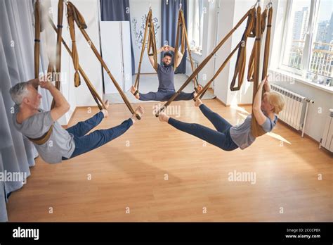 Qualified Trainer And Beginners Practicing Anti Gravity Yoga Stock