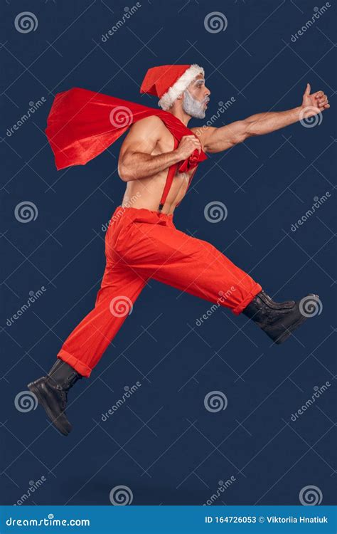 Nude Santa Claus Jumping Up With Sack Full Of Presents Stock Image