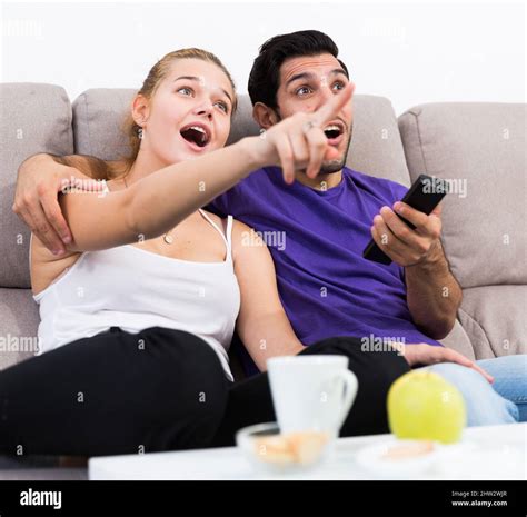 Cheerful couple on couch watching TV Stock Photo - Alamy