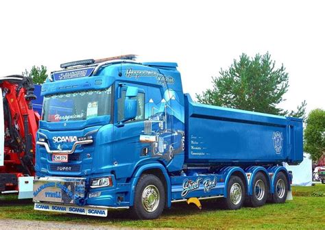 A Blue Dump Truck Parked In The Grass