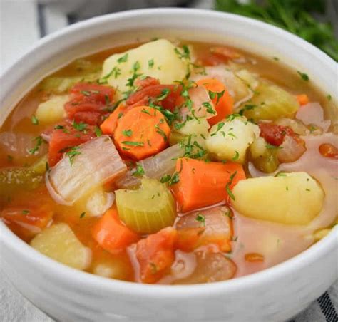 Two Bowls Of Soup With Carrots Potatoes And Celery On A Table