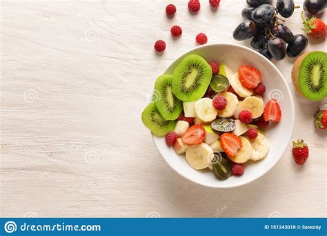 Bacia Salada De Fruto Saboroso Na Tabela De Madeira Branca Foto De