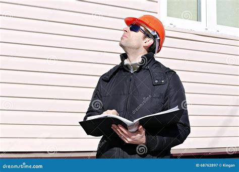 Le Travailleur Sur Un Chantier De Construction En Hiver Regarde Le