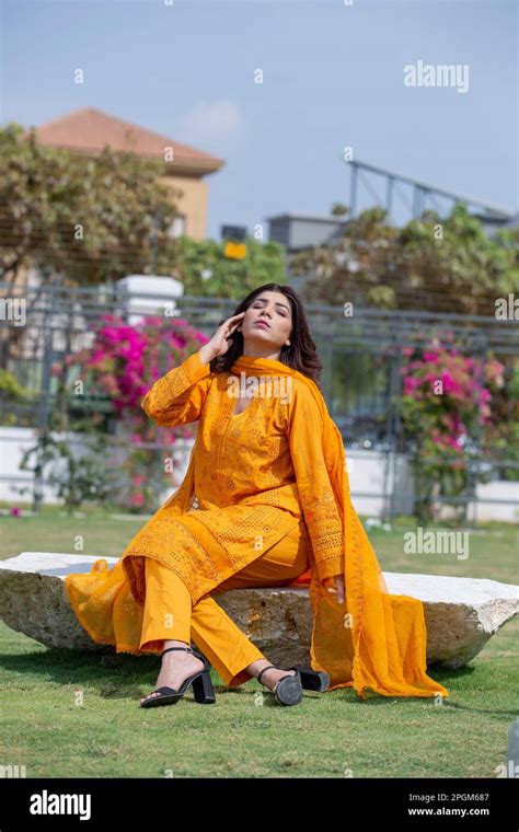 Female Model Posing Outdoors Wearing Orange Indian Pakistani Asian Traditional Salwar Kameez