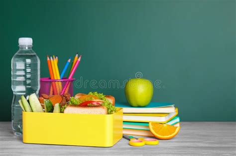 Lunch Box With Healthy Food And Different Stationery On Wooden Table
