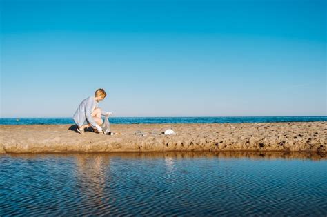 Mujer recoger basura plástica en la playa de arena del mar basura