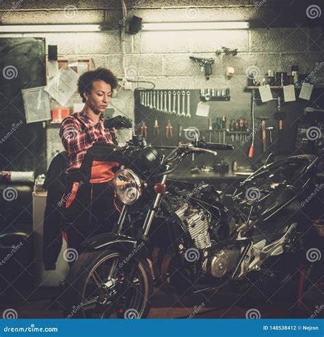 African American Woman Mechanic Repairing A Motorcycle In A Workshop