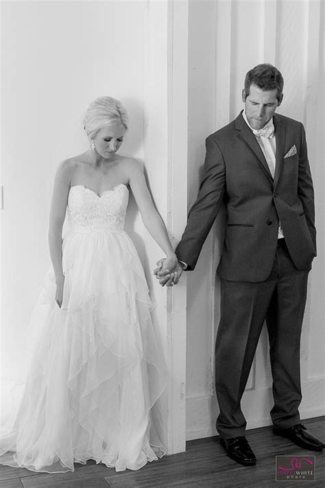 Bride And Groom Holding Hands On Either Side Of The Wall Before Seeing