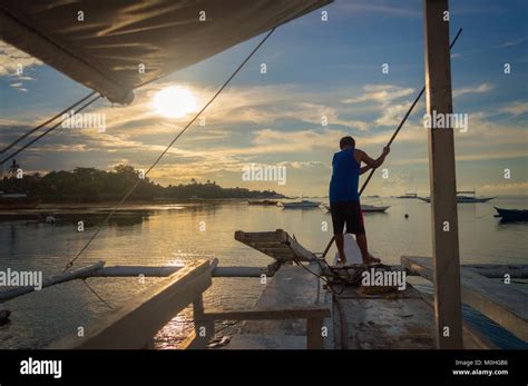 Fisherman On A Banka Traditional Filipino Fishing Boat At Sunset Cebu