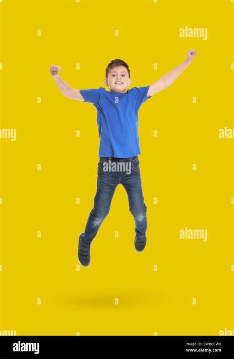 Happy Boy Jumping On Golden Background Full Length Portrait Stock