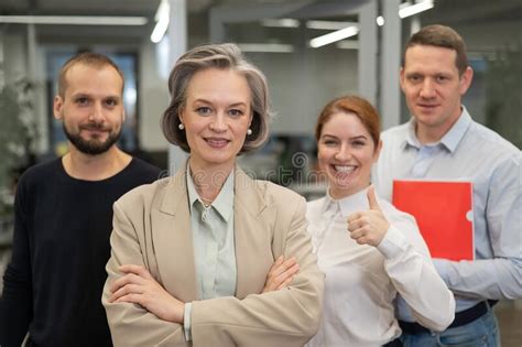 Portrait Of Four Office Workers A Gray Haired Mature Woman A