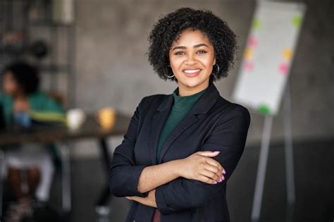 Retrato de uma feliz mulher de negócios negra sorrindo de pé em um