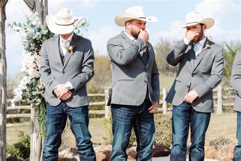 A Group Of Men Standing Next To Each Other In Front Of A Wooden