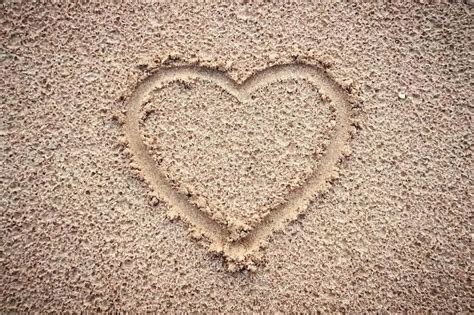 Premium Photo | Heart on a sand of beach on background