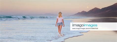 Lady Walking On Sandy Beach In Sunset Woman Walking On Sandy Beach In