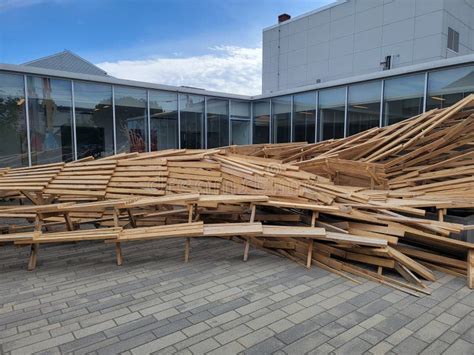 Pile Or Mound Of Wood Tables Outside Building With Windows Stock Photo