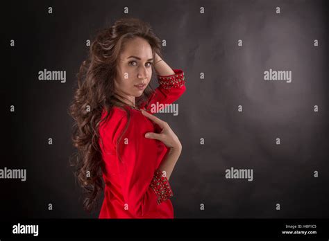 The Charming Brunette In A Red Dress On A Black Background Stock Photo Alamy