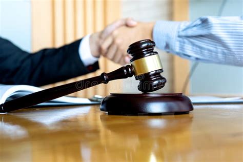 Lawyer Or Judge Gavel With Balance Handshake With Client Stock Photo