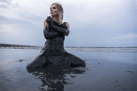 Portrait De La Pose Caucasienne Blonde De Fille Enduit Dans Une Boue Noire Saine Dans Vieux