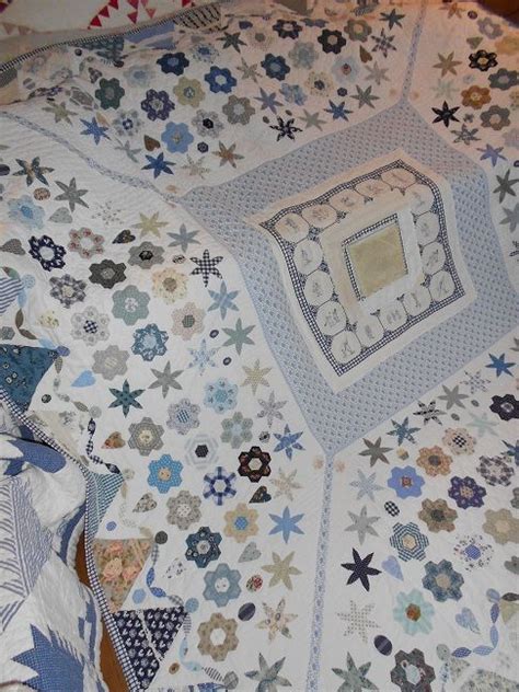 A Quilt Is Laying On Top Of A Bed With Blue And White Stars All Over It