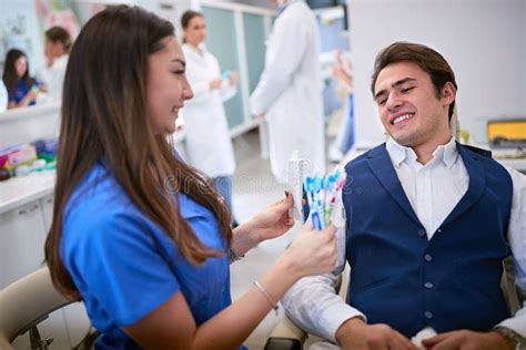 Dentist Showing Best Toothbrushes And Toothpaste To Patient Stock Image