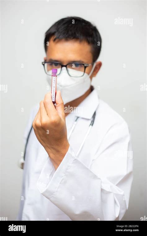 Doctor In Personal Protective Suit Holding Covid Blood Sample Tube On