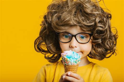 Premium Photo Boy With Long Hair Happily Eats Ice Cream