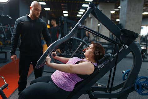 Mujer Con Sobrepeso Con Entrenador Haciendo Gimnasia Foto De Archivo