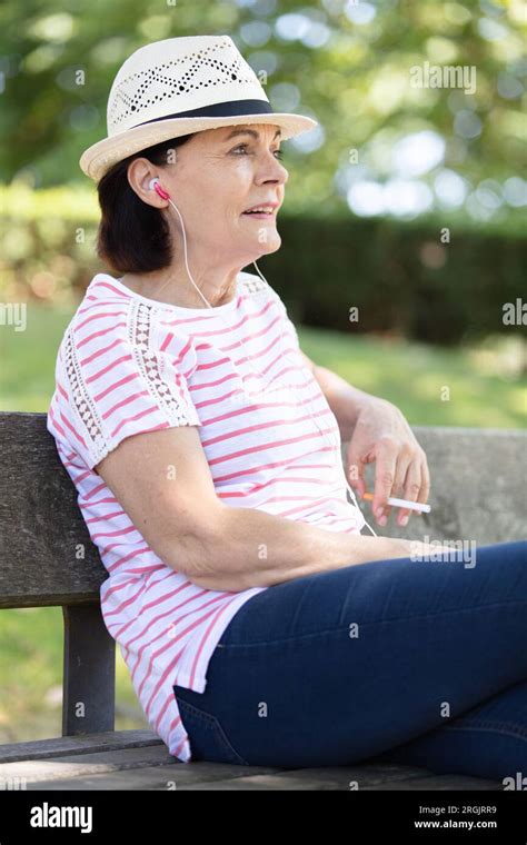 Vieille Dame Assise Sur Un Banc En Bois Banque De Photographies Et D