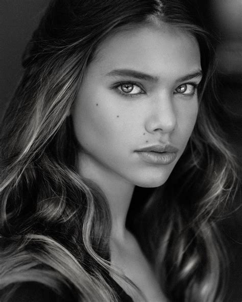 A Woman With Long Hair And Blue Eyes Posing For A Black And White Photo