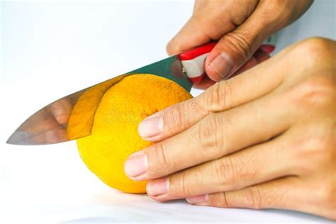 Photo Of A Hand Holding A Lemon And Cutting A Lemon Using A Knife