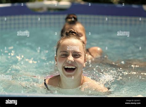 Happy Children Swim In Swimming Pool On Sunny Summer Day Summertime