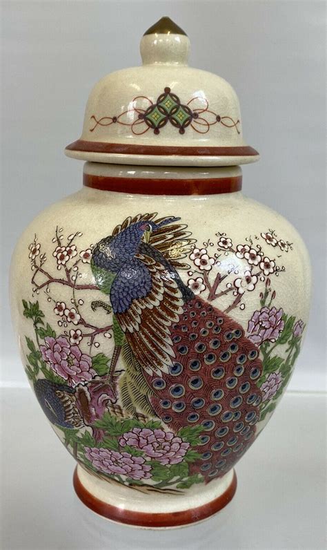 An Ornate Vase With A Peacock Painted On The Front And Sides Sitting