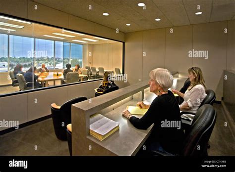 A Moderator Directs A Marketing Focus Group As Clients Watch Through A