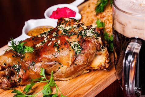 German Style Roasted Pork Hock Knuckle Shank With Beer On Wooden