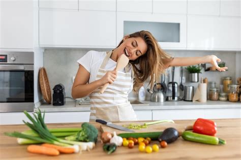 Premium Photo Funny Beautiful Woman Singing Into Spatula Cooking In