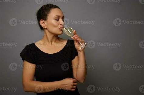 Cheerful Woman In Black Outfit Drinks Sparkling Wine From A Glass