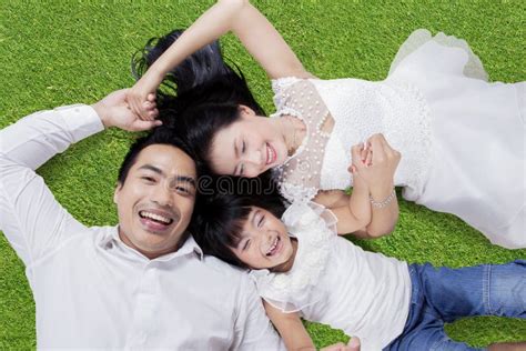 Two Parents And Child Lying On Grass Stock Photo Image Of Girl