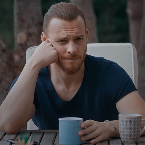 A Man Sitting At A Table With A Coffee Cup In Front Of Him And His Hand