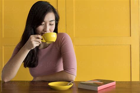 Asian Woman Drinking Coffee With Yellow Background By Stocksy Contributor Eyes On Asia Stocksy