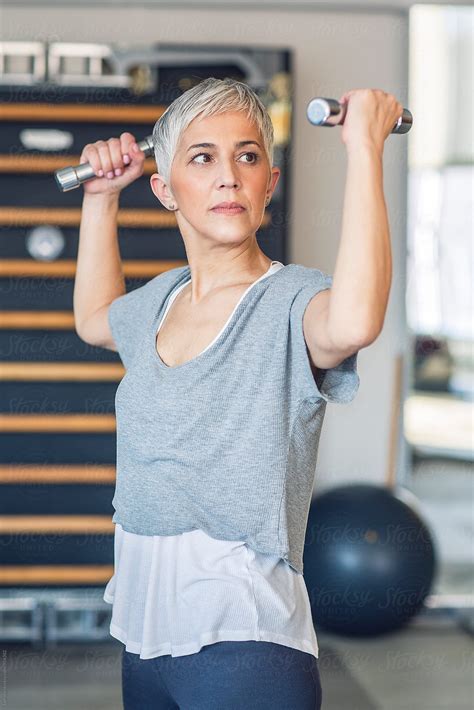 Woman Lifting Weights In The Gym By Stocksy Contributor Lumina