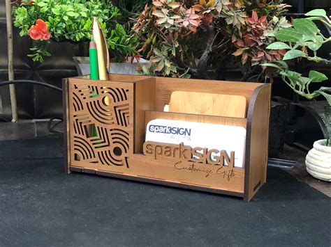 A Wooden Desk Organizer Sitting On Top Of A Black Table Next To Potted