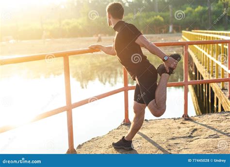 Fitness Man Stretching His Leg Before A Run Outdoors Stock Photo