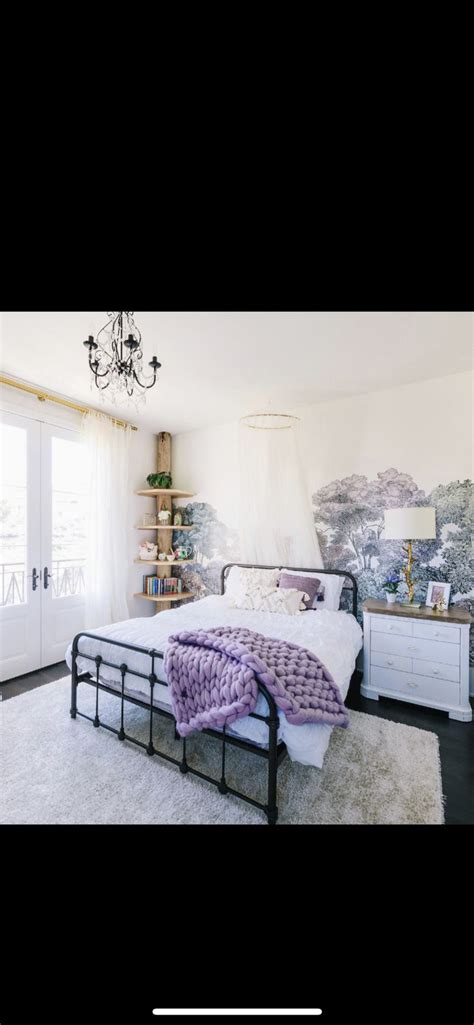 A Bed Room With A Neatly Made Bed And A Chandelier Hanging From The Ceiling