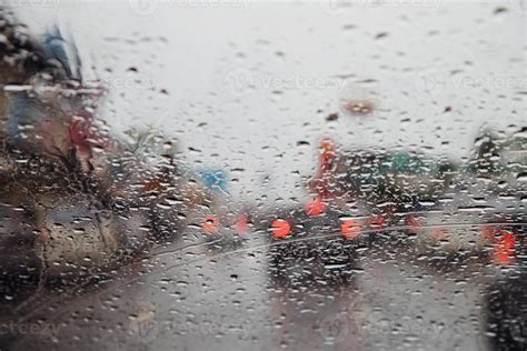 Drops Of Rain Drizzle On The Glass Windshield In The Evening Street In